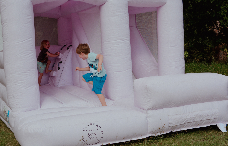 niños juegan en un castillo hinchable rosa